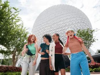 Four young women walking in front of Spaceship Earth in EPCOT