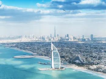 Dubai Skyline The Burj Al Arab on an island out at sea shaped like a boat sail and in the background you can see the whole city skyline.