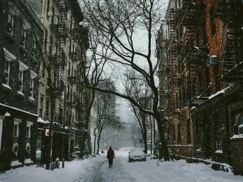 Winter in New York Snow on the streets of New York with someone walking down it.