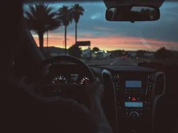 Person driving with two hands on the wheel and LA in the window.