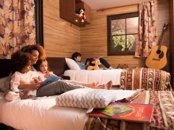 Disney Davy Crockett Ranch A family sitting on a hotel room bed reading a book