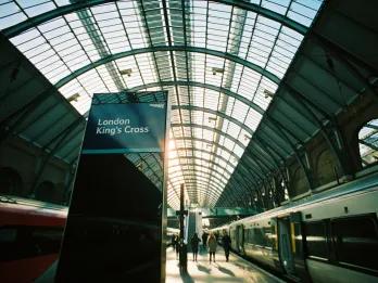 Kings Cross Station Large train station with a train waiting for passengers. There's a sign saying Kings Cross Station