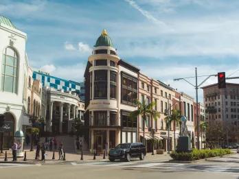 Rodeo Drive Glamorous shops and restaurants lining the corner of a street.