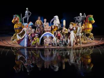 Gymnasts dressed in funky costumes and using fun props like colourful horse