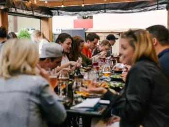 People sat around a long table tucking into meals 