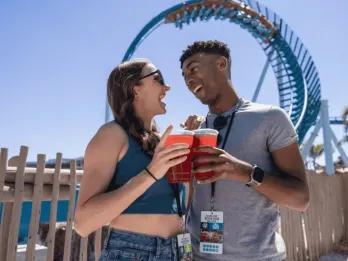 Couple having drinks at SeaWorld Orlando in front of Pipeline: The Surf Coaster