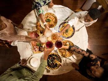A bird's eye view of a family sat round a table cheersing their drinks
