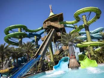 Tonga of Taniwha Tubes Large tower with four weaving slides of different shades of blue and green.