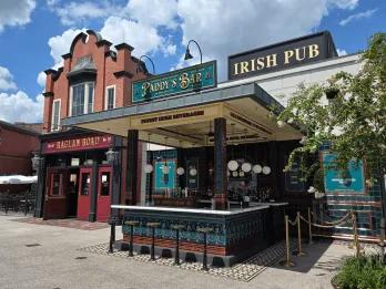 Raglan Road at Disney Springs An irish pub with a sign saying Raglan Road Irish Pub, there is a bar and multiple bar stools.