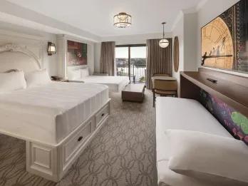 A hotel room with a double bed and pull out bed with Princess artwork
