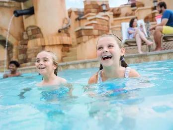 Two young girls in a Caribbean themed swimming pool