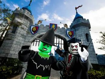LEGOLAND’S Brick-or-Treat A lego green witch and a lego vampire at the gates of a castle.