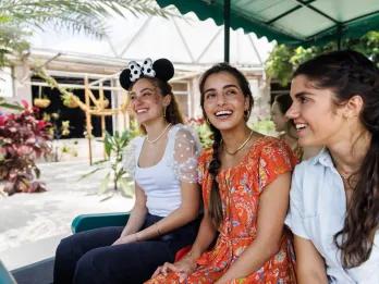 Three young women on a boat ride through a greenhouse
