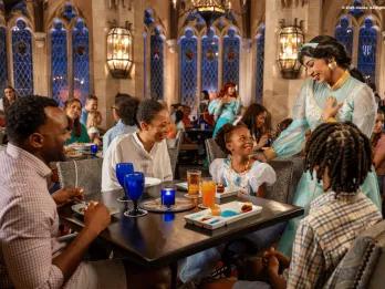 Guests smiling during a Character Dining experience as Princess Jasmine interacts with a family, showcasing a premium Walt Disney World dining option perfect for young children and families.