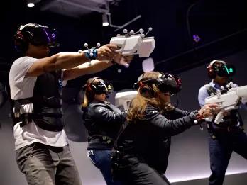 Sandbox VR in Orlando A group of adults shooting fake guns in a VR experience