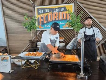 Buffet style food served by a chef in clean, modern restaurant with another chef stood behind.