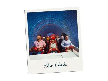 Three people on a red roller coaster going through a bright colourful tunnel.