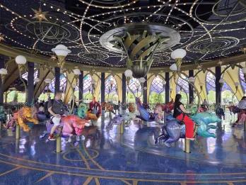 People sat on a carousel made of hand carved animals, including lions, bulls and other animals associated with zodiac signs.