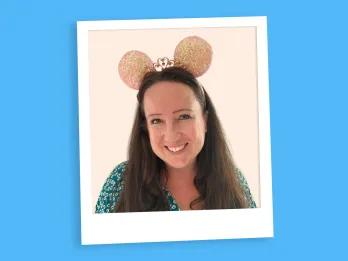 woman with long brown hair and pink minnie mouse ears smiling