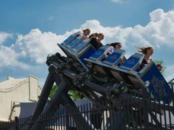 Families riding a thrilling roller coaster at a theme park