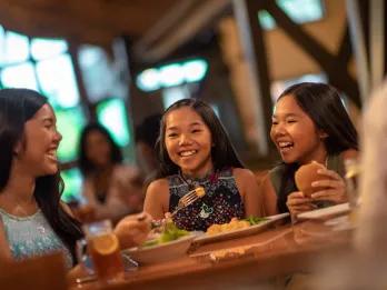 A group of young girls eating a quick service meal around a table