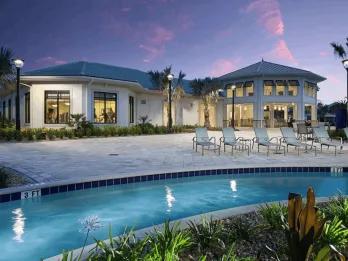 Lazy river and clubhouse with lounge chairs at Storey Lake Resort during dusk