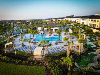 Aerial view of a resort pool, water play area and mini golf course at an Orlando villa community near Championsgate and Davenport