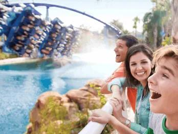 A family laughing and cheering as Manta roller coaster splashes down beside them at SeaWorld Orlando