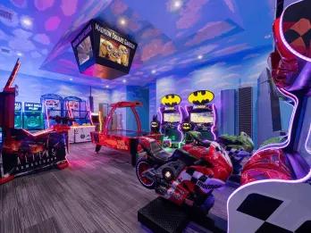 Themed arcade games room with motorcycle simulators, air hockey and skee ball at an Orlando villa