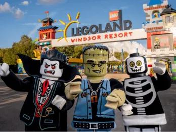 Three costumed Lego Halloween characters standing in front of the Legoland Windsor Resort entrance