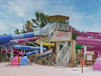 Entrance sign and colorful water slides for The Crab attraction at Caribe Aquatic Park