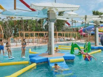 People playing on a water obstacle course and rope swings at Bahía Pirata in Caribe Aquatic Park