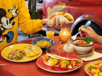 Table filled with colorful Mexican dishes including tacos, salmon, rice, and chili at La Cantina