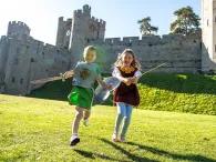 Boy and girl in medieval costume in front of Warwick Castle