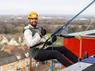 person-abseiling-over-roof-edge
