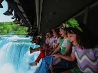 Soarin' Around the World A row of people on a ride vehicle hanging a screen showing a waterfall