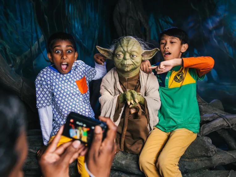 2 boys having their photo taken with Yoda at Madame Tussauds London