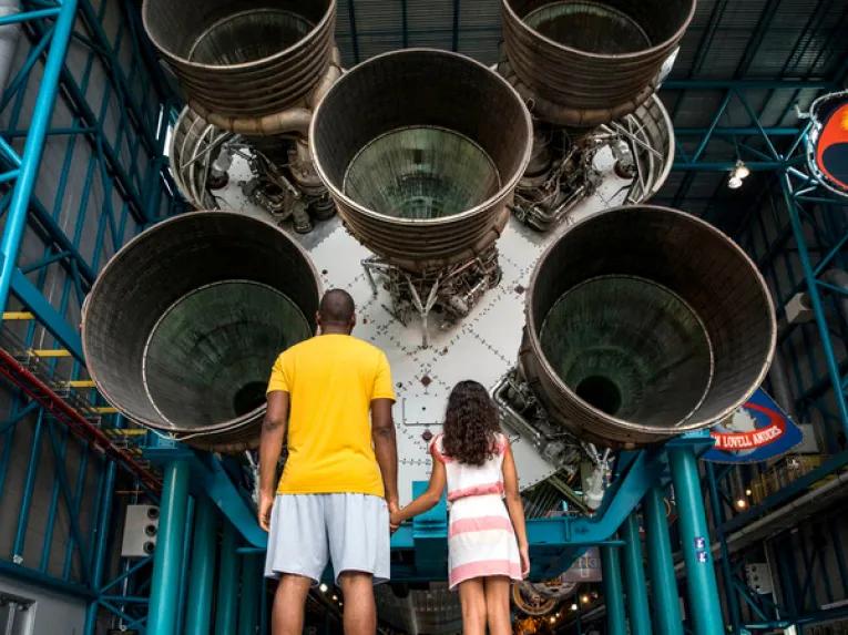 Father and daughter in front of Apollo Saturn V Rocket at Kennedy Space Center