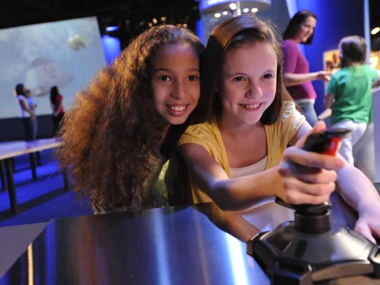 Girls playing with Exploration Space Simulators at Kennedy Space Center