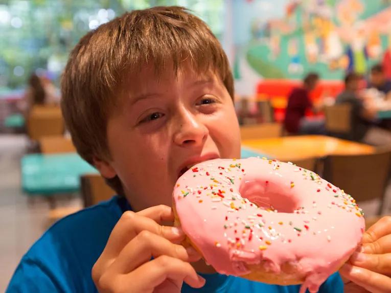 Boy eating a doughnut in Krustyland at Universal Studios Florida