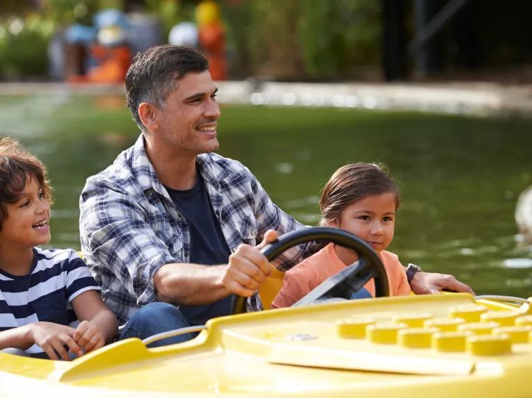 Father driving kids in a boat on Coast Guard HQ at LEGOLAND Windsor