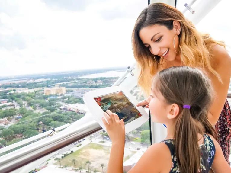 A lady and a young girl on the The Wheel at ICON Park™