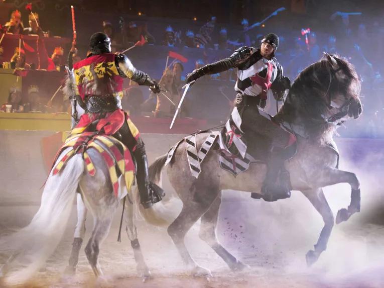 Knights with swords on horseback at Knights riding horses in the arena at Medieval Times Orlando Dinner Show & Tournament