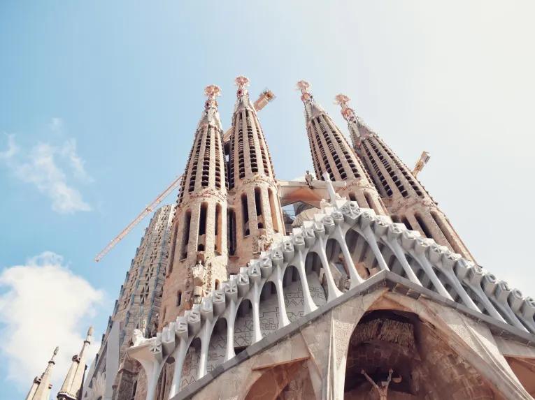Looking up at the large towers of the Sagrada Familia in front of a blue sky
