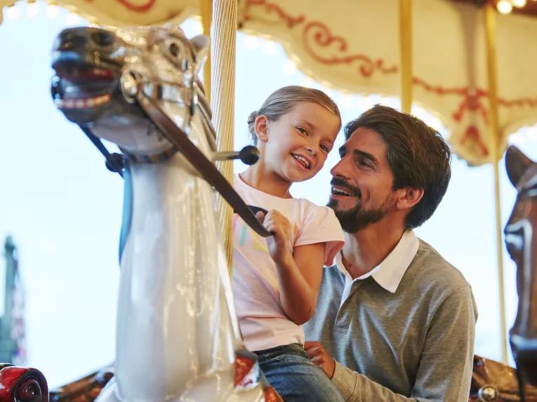 Father and daughter on a merry-go-round at PortAventura theme park