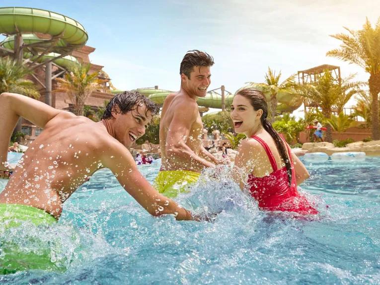 Adults splashing around in the lazy river at Aquaventure Dubai