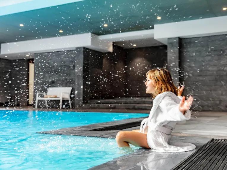 Woman next to indoor pool at Relais Spa Val d'Europe 