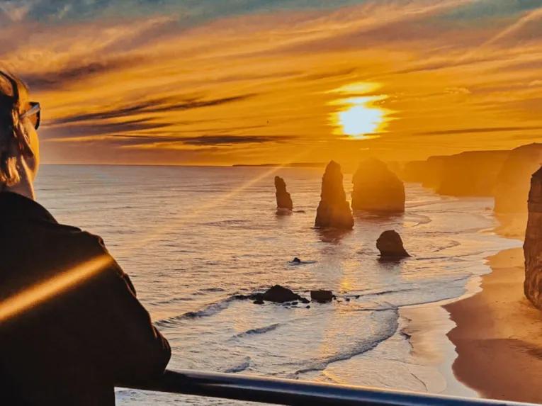 Person watching a stunning ocean sunset on the Great Ocean Road Sunset Tour