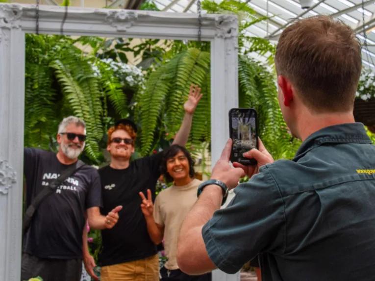 Tour guide taking a photo of three happy people smiling during the Melbourne City Discovery Tour