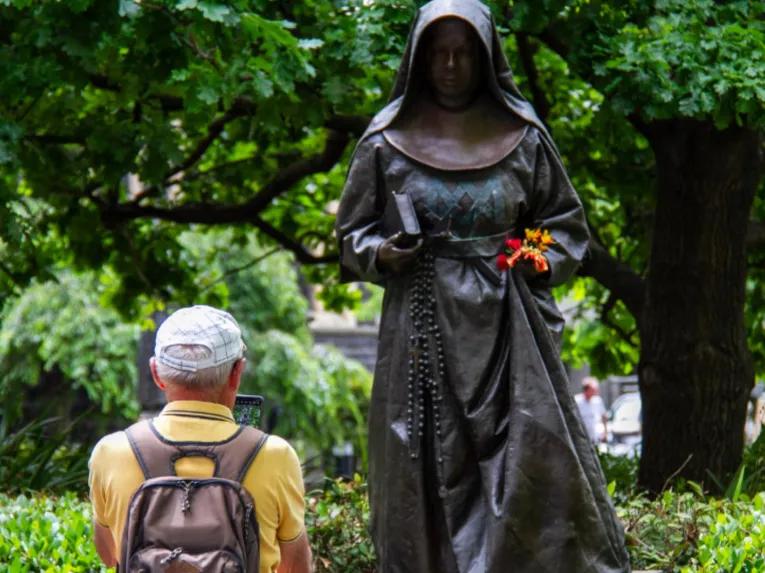 Person taking a photo of a statue outside St Patrick’s Cathedral during the Melbourne City Discovery Tour